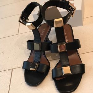Black sandals with heel and ankle strap.